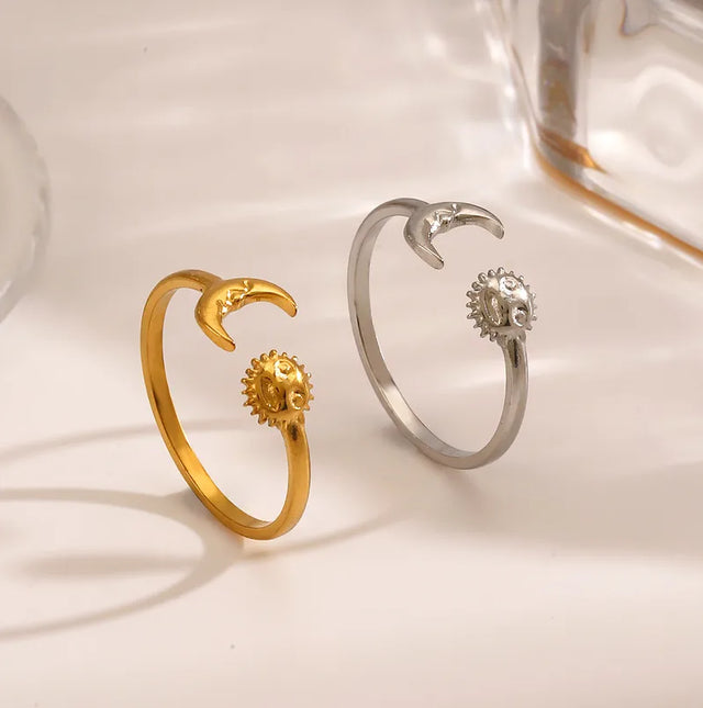 Gold and silver open ringwith sun and moon design on a soft white background