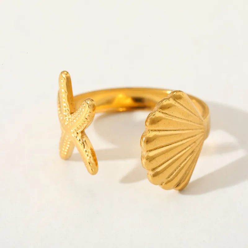 gold shell ring, starfish ring, beach jewelry, ocean inspired ring, adjustable gold ring, shell statement ring, women’s fashion ring, coastal jewelry, trendy gold ring, vacation jewelry, summer accessories, boho ring, stainless steel ring, sea life jewelry, luxury adjustable ring